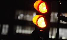 A traffic light with the top two lights lit up yellow, and the bottom light dark